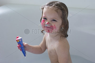 Little girl playing in bathtub