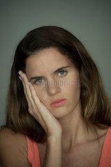 Young woman resting face on hand  portrait