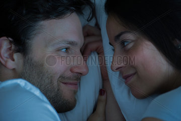 Couple lying in bed  looking at each other