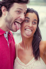 Couple sticking out tongues
