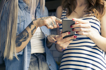 Women using smartphone together  cropped