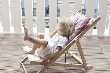 Little girl sitting on deckchair