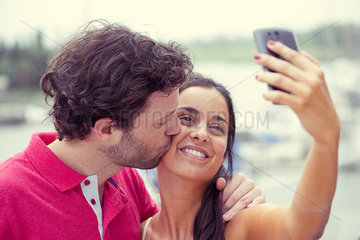 Man and woman posing for selfie taken with smart phone