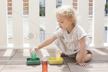 Little girl playing with toys outdoors