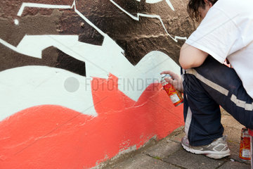 Bremen  Deutschland  Graffitikuenstler besprayt eine Wand im Auftrag der Stadt