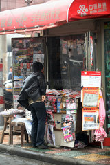 Shanghai  Mann an einem Zeitungskiosk