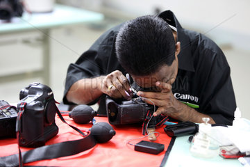 Dubai  Vereinigte Arabische Emirate  Mitarbeiter des Canon Professional Service reinigt eine Spiegelreflexkamera