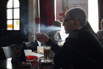 Posen  Polen  ein Mann raucht eine Zigarette im Cafe