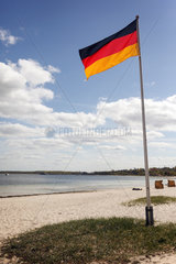 Eckernfoerde  Deutschland  Fahnenmast mit Deutschlandfahne am Strand