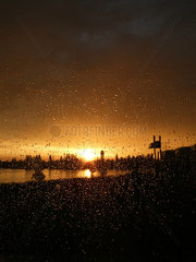 Berlin  Regentropfen an Fensterscheibe beim Sonnenuntergang