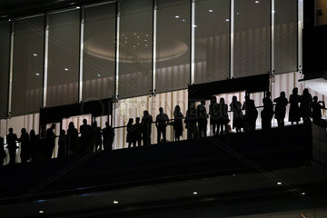 Dubai  Vereinigte Arabische Emirate  Silhouette  Menschen stehen in der Nacht auf einem Balkon nebeneinander