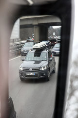 Allersberg  Deutschland  PKW mit Dachgepaecktraeger spiegelt sich im linken Aussenspiegel eines Reisebusses