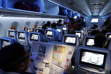 Hongkong  China  Menschen in einer Flugzeugkabine