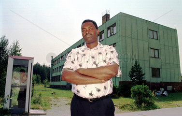 Thomas Mazimpaka mit dem Asylantenheim Langebrueck im Hintergrund  Sachsen  Deutschland