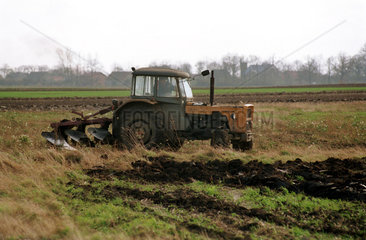 Landwirt pfluegt sein Feld mit einem Traktor  Brzeg  Polen