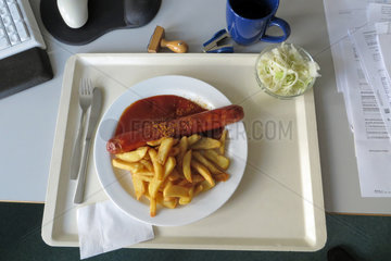 Berlin  Deutschland  Mittagessen im Buero  Currywurst mit Pommes und Krautsalat