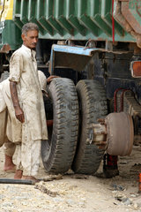 Karatschi  Pakistan  Maenner wechseln einen LKW-Reifen