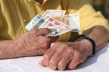 Berlin  Deutschland  eine Rentnerin haelt Geldscheine in der Hand