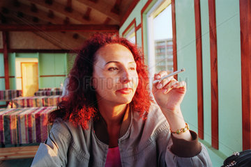 Nachdenklich schauende Frau mit Zigarette  Russland