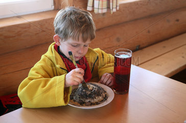 Krippenbrunn  Oesterreich  Kind isst einen Germknoedel