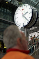 Berlin  Deutschland  Mann und Uhr im Berliner Hauptbahnhof