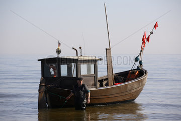 Fischer zieht seinen Fischkutter Richtung Ufer
