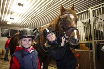 Neuenhagen  Deutschland  Maedchen in einem Pferdestall