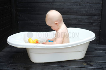 Freiburg  Deutschland  Baby badet in einer Wanne