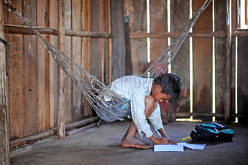 Phum Chikha  Kambodscha  ein Junge bei seinen Schularbeiten