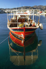 Agios Nikolaos  Fischerboot spiegelt sich auf der Wasseroberflaeche