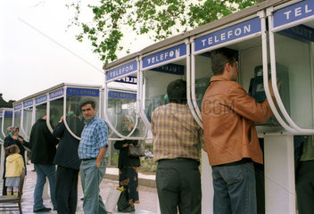 Telefonierende Menschen an einem Platz in Istanbul