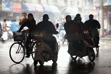 Shanghai  Silhouette von Fahrrad- und Motorradfahrern