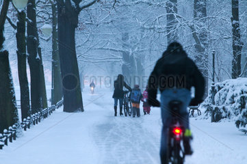 Berlin  Deutschland  Passanten und Radfahrer im verschneiten Tiergarten