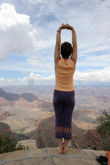Flagstaff  USA  eine Frau macht Dehnungsuebungen am Rand des Grand Canyon