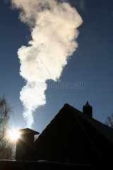 Goerlsdorf  Deutschland  Rauchender Schornstein auf einem Hausdach