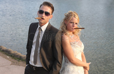 Berlin  Deutschland  ein Brautpaar posiert mit Zigarre als Mafiapaerchen