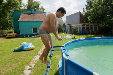 Breslau  Polen  Mann steigt in sein aufblasbares Pool im Garten