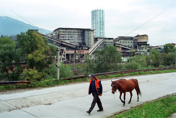 Einheimischer mit Pferd  dahinter ein Bergwerk  Rumaenien