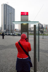 Berlin  eine Frau an einer oeffentlichen Telefonzelle