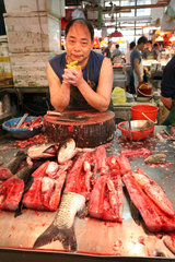 Macau  China  Fischhaendler wartet auf Kundschaft