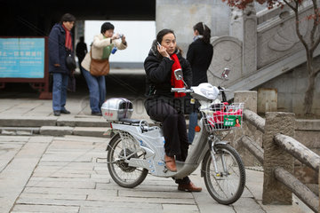 Suzhou  Mopedfahrer telefoniert mit seinem Mobiltelefon