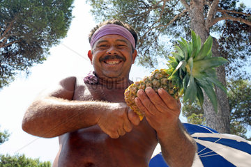 Cala D'Or  ein Mann schneidet eine Ananas auf