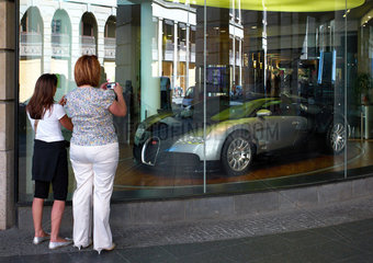 Berlin  Deutschland  zwei Frauen fotografieren einen Bugatti in einem Schaufenster