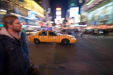 New York  junger Mann und Taxi auf dem Time Square