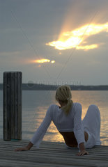 Junge Frau betrachtet entspannt den Sonnenuntergang  Bahamas