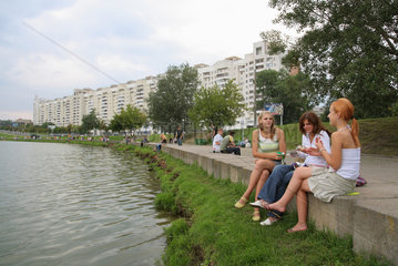 Minsk  Weissrussland  Freundinnen sitzen zusammen am Komsomolskoje-See