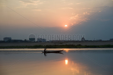 Phnom Penh  Kambodscha  ein Fischer auf seinem Boot im Sonnenuntergang