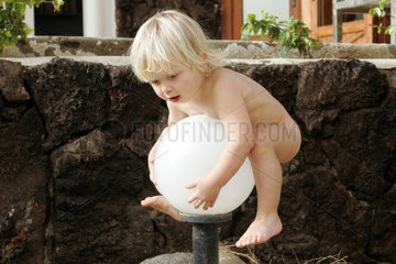 Pajara  ein nacktes Kind klettert auf eine Lampe