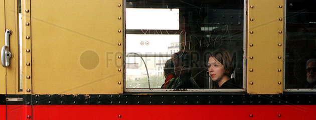 Junge Frau sitzt in S-Bahn  schaut vertraeumt aus Fenster
