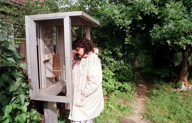 Istra  Frau telefoniert in einer kaputten oeffentlichen Telefonzelle
